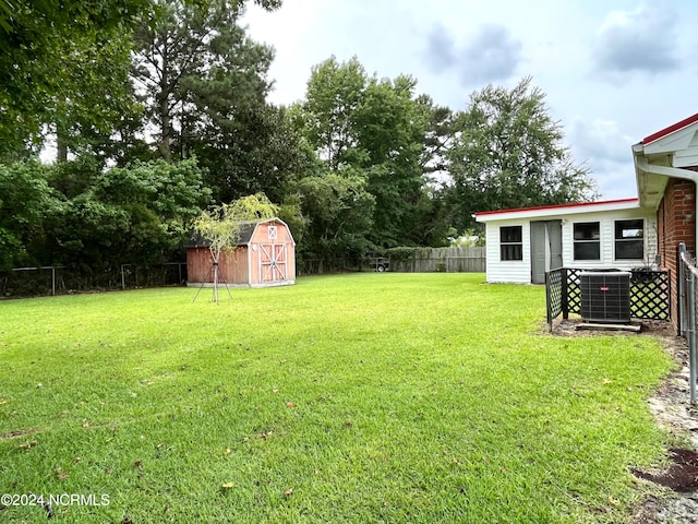 view of yard with central air condition unit and a storage shed