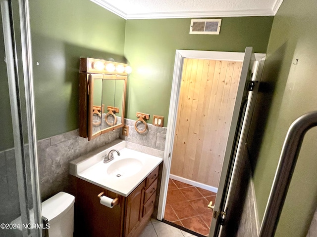 bathroom with tile patterned floors, vanity, toilet, and crown molding