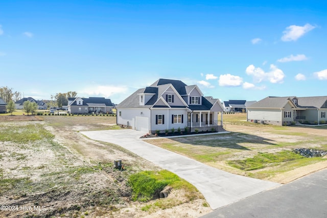 view of front of house featuring a front yard, a garage, and covered porch