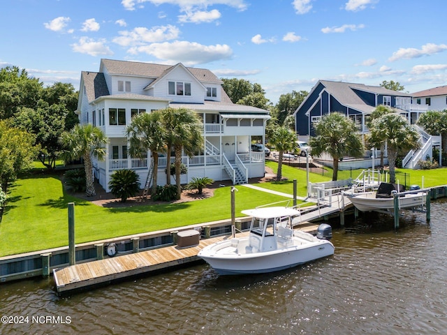 back of house featuring a residential view, a water view, a yard, and stairs