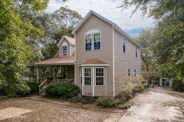 view of front of home featuring a porch and fence