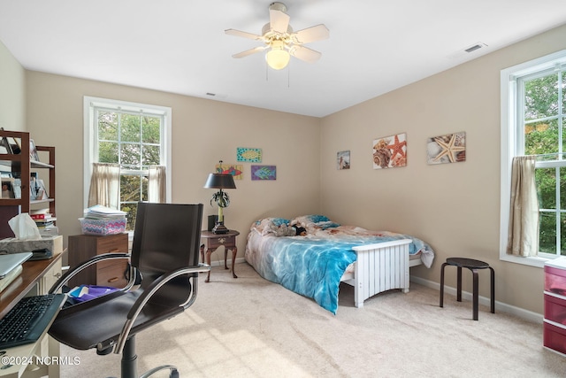 carpeted bedroom with multiple windows and ceiling fan