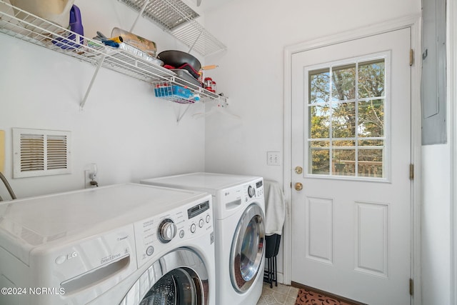 clothes washing area with washing machine and dryer and light tile patterned floors