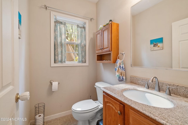 bathroom featuring vanity, tile patterned floors, and toilet