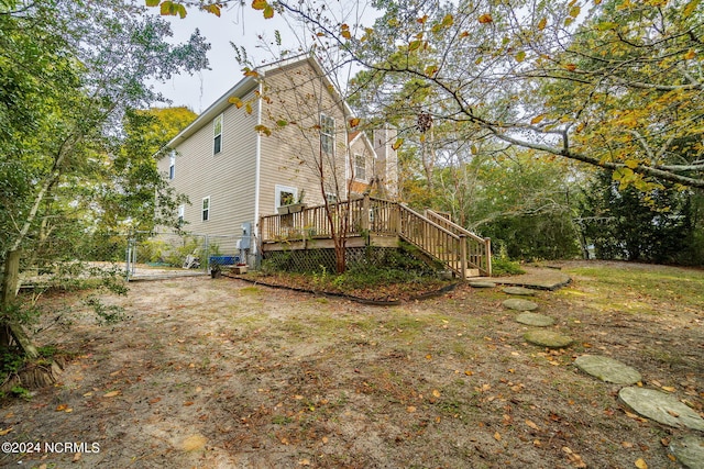 rear view of house featuring a deck, stairs, and a gate