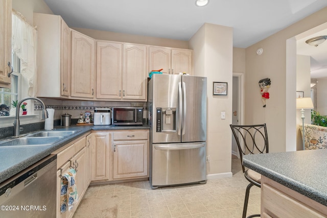 kitchen featuring appliances with stainless steel finishes, backsplash, light tile patterned floors, and sink