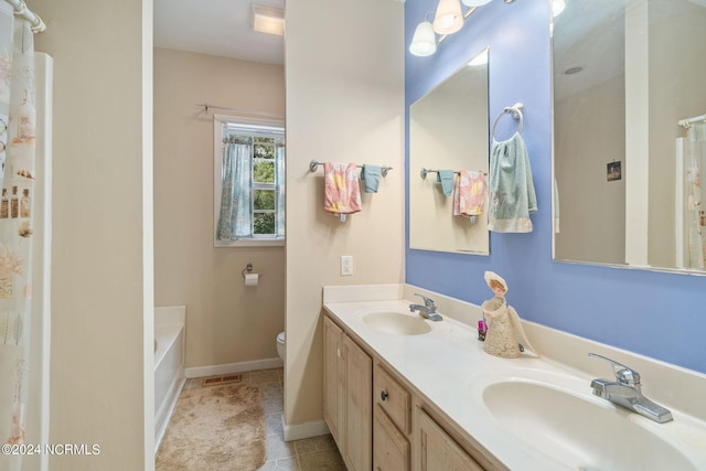 bathroom with toilet, double sink vanity, and tile patterned flooring