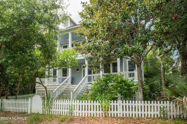 view of front of property featuring a fenced front yard, stairway, and a porch