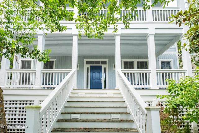 view of exterior entry featuring covered porch