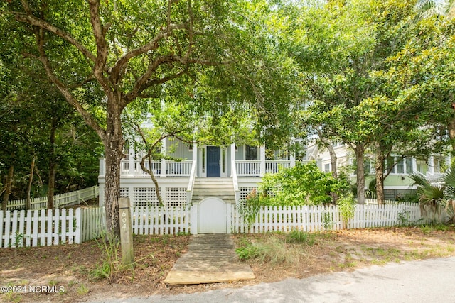 604 Currituck Way, Bald Head Island, NC 28461 - view of property hidden behind natural elements featuring covered porch, a gate, and a fenced front yard