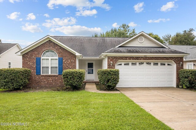 ranch-style home featuring a garage and a front lawn