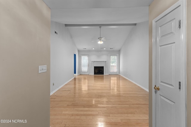 unfurnished living room with vaulted ceiling with beams, ceiling fan, light wood-type flooring, and a high end fireplace