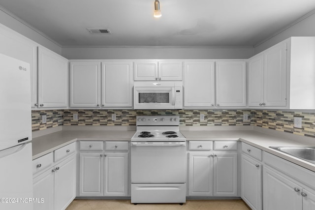 kitchen with tasteful backsplash, white appliances, and white cabinets