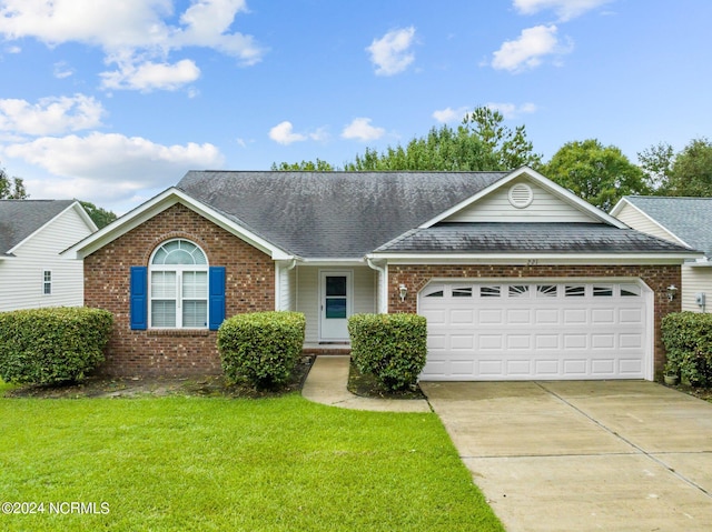 single story home with a garage and a front lawn