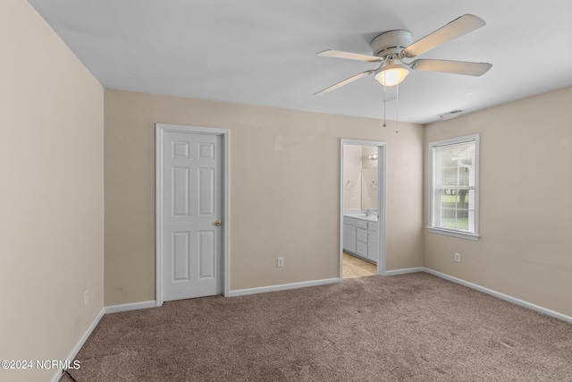 spare room with sink, light colored carpet, and ceiling fan