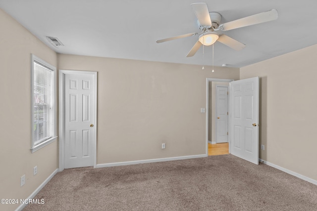 carpeted spare room featuring ceiling fan