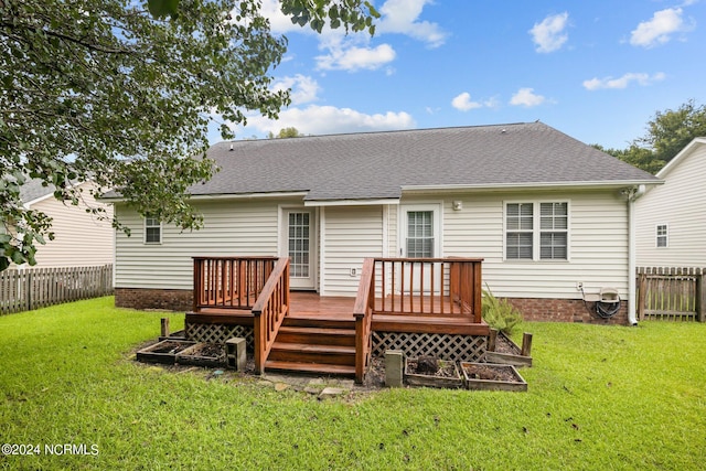 rear view of property featuring a deck and a yard