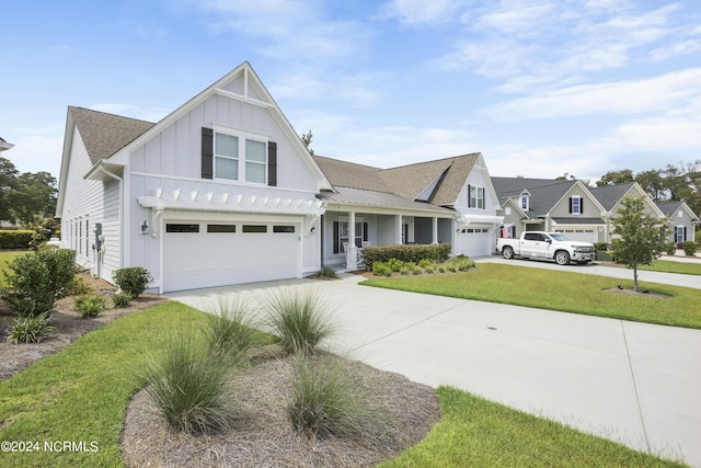 view of front of house featuring driveway, an attached garage, a front lawn, and board and batten siding