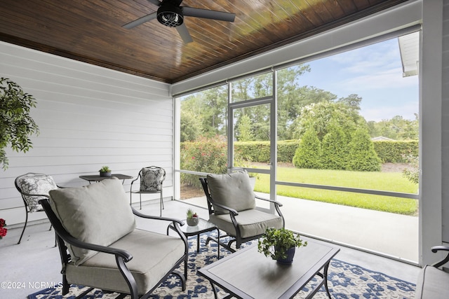 sunroom / solarium with a ceiling fan and wooden ceiling