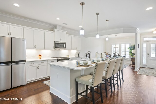 kitchen featuring decorative backsplash, dark hardwood / wood-style flooring, stainless steel appliances, and an island with sink