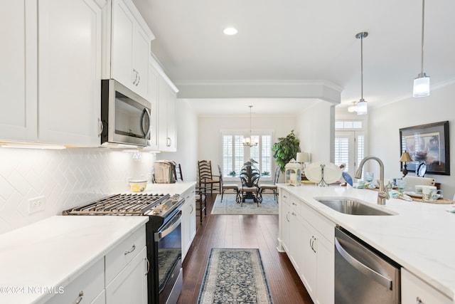 kitchen with decorative backsplash, appliances with stainless steel finishes, sink, crown molding, and dark hardwood / wood-style flooring