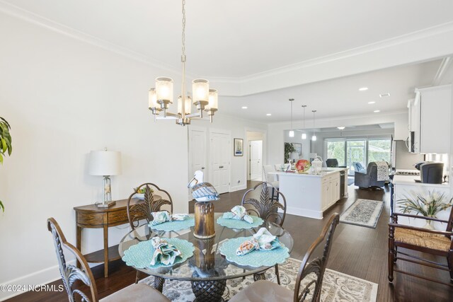 dining area with a notable chandelier, crown molding, and hardwood / wood-style flooring