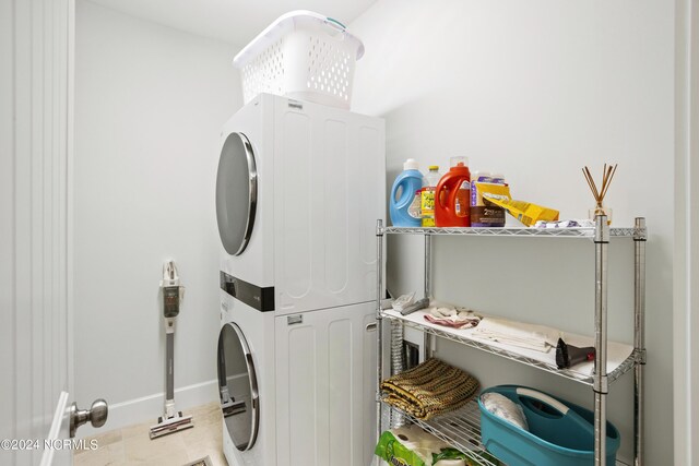 washroom with light tile patterned flooring and stacked washing maching and dryer