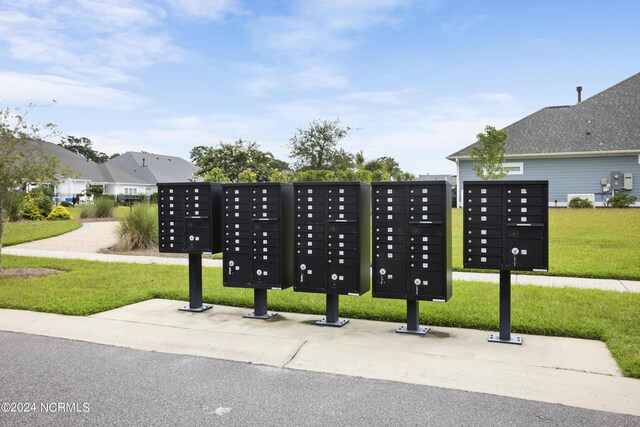 view of property's community featuring a lawn and mail boxes