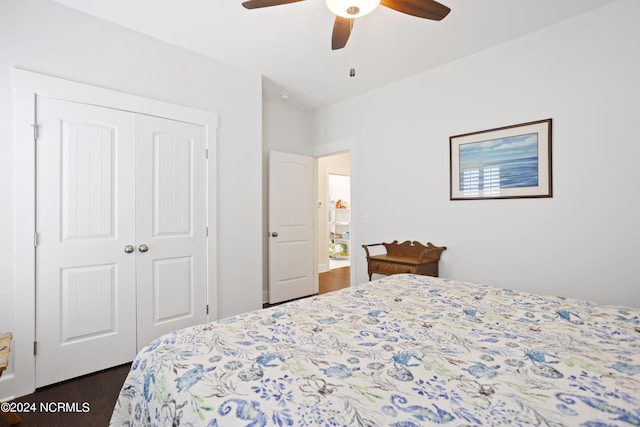 bedroom with ceiling fan, dark wood-type flooring, and a closet