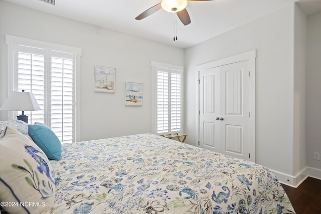 bedroom featuring a ceiling fan, a closet, dark wood finished floors, and baseboards