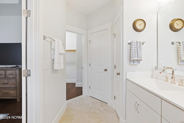 bathroom featuring a closet, vanity, and baseboards