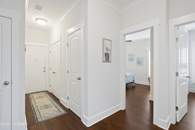 hallway with baseboards, dark wood-type flooring, and crown molding