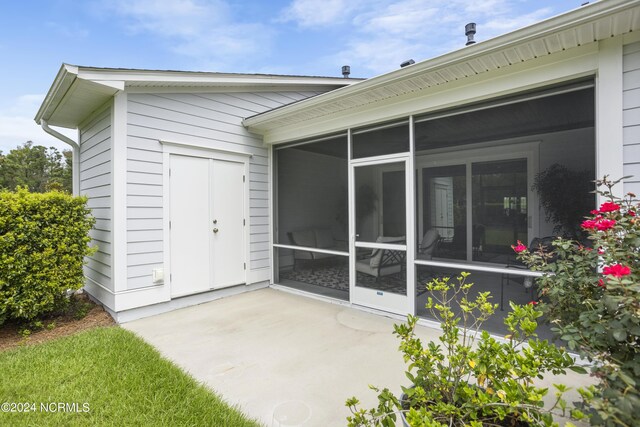 back of house featuring a sunroom and a patio area