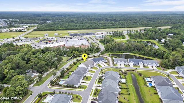 drone / aerial view featuring a residential view and a wooded view