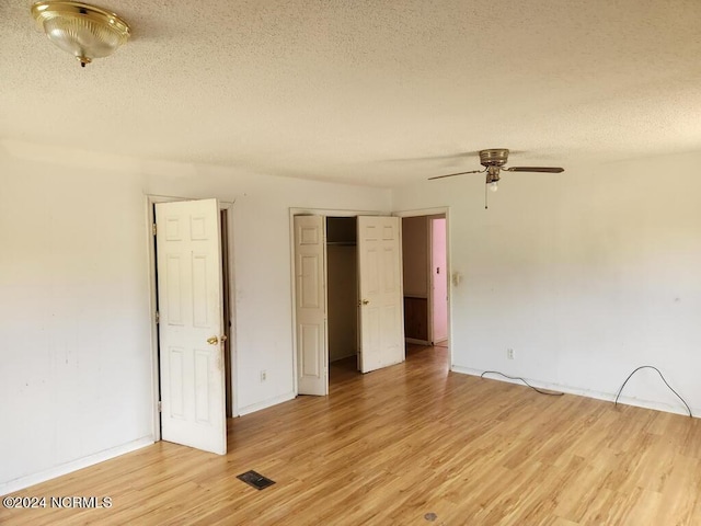 unfurnished room featuring ceiling fan, a textured ceiling, and light wood-type flooring