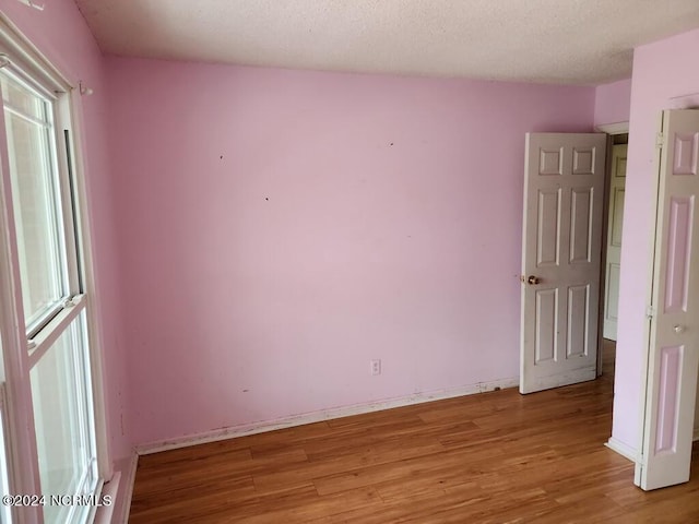 empty room featuring a textured ceiling and light wood-type flooring