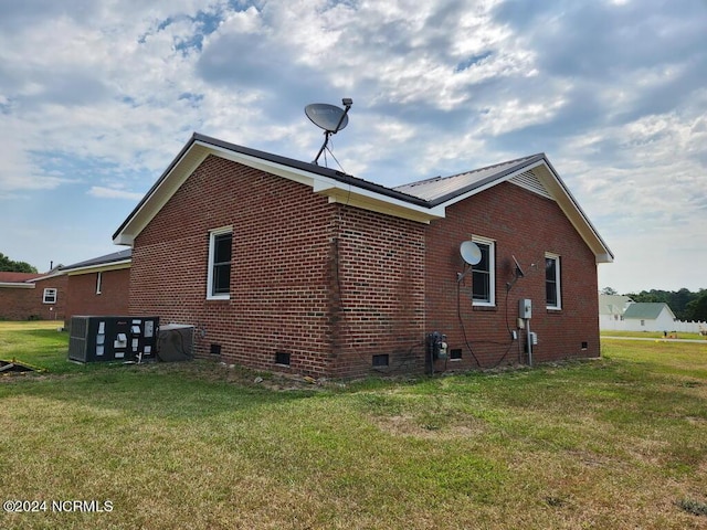 view of side of property with cooling unit and a lawn