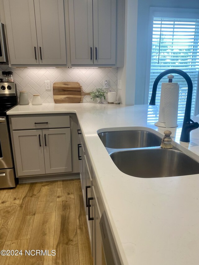 kitchen featuring stainless steel dishwasher, sink, a large fireplace, and a wealth of natural light