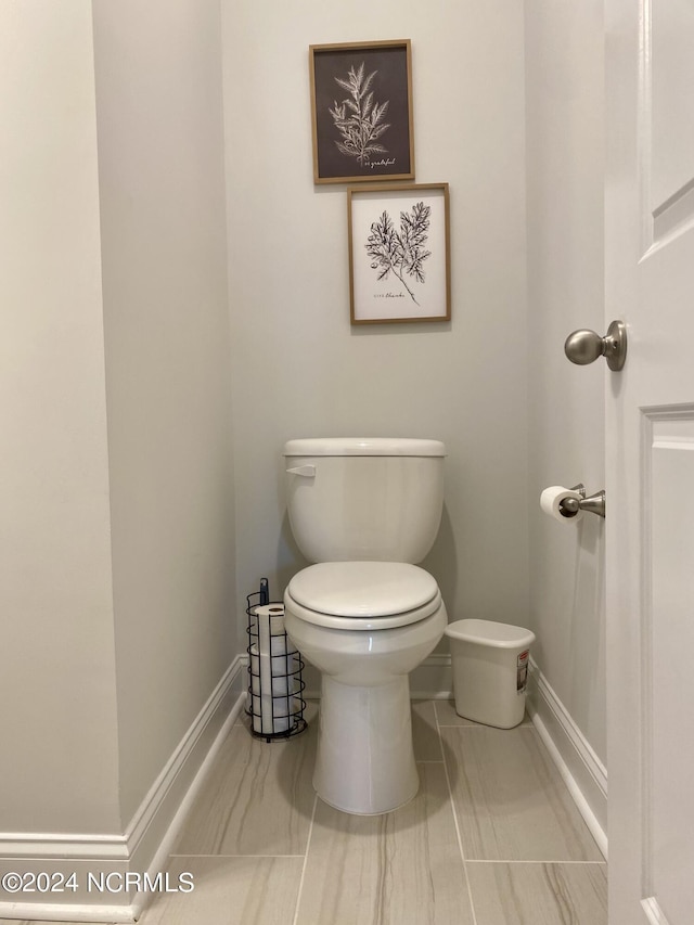 bathroom with toilet and baseboards