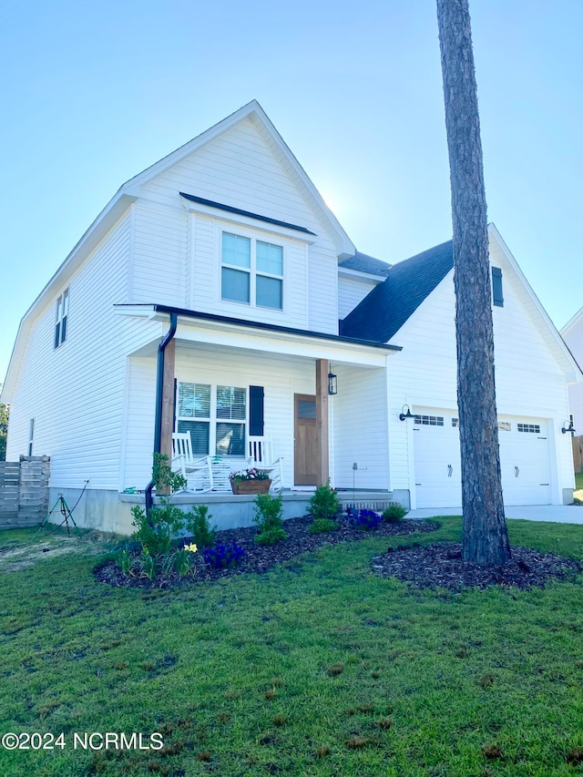 view of front facade with covered porch, a front yard, and a garage