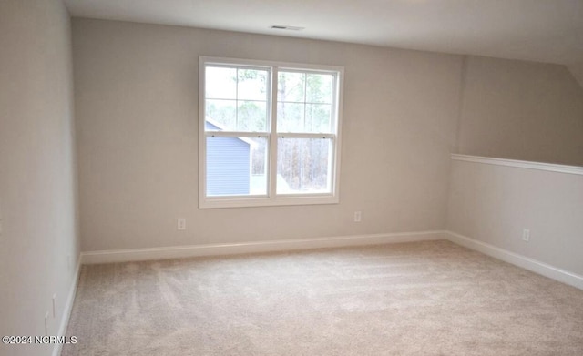 empty room featuring light carpet, visible vents, and baseboards