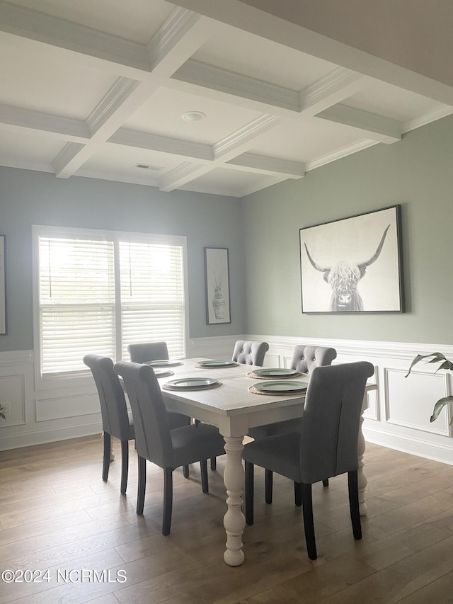 dining space featuring a wainscoted wall, beamed ceiling, coffered ceiling, and wood finished floors