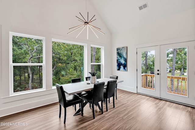 dining room featuring an inviting chandelier, plenty of natural light, french doors, and light wood-type flooring