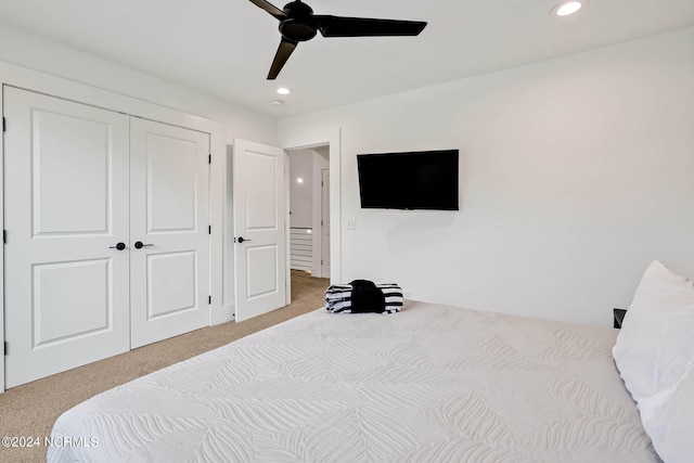 carpeted bedroom featuring ceiling fan and a closet