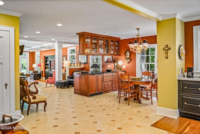 kitchen with pendant lighting, ornamental molding, and ornate columns