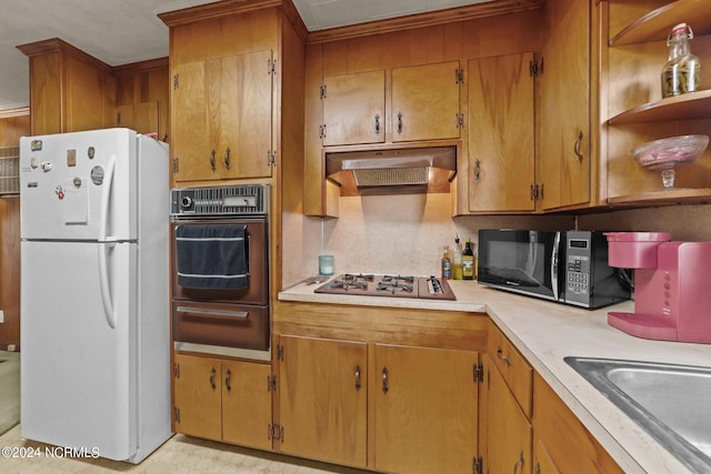 kitchen featuring gas cooktop, oven, sink, and white fridge