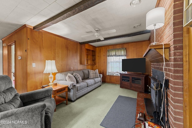 carpeted living room featuring ceiling fan, a fireplace, beam ceiling, and wood walls