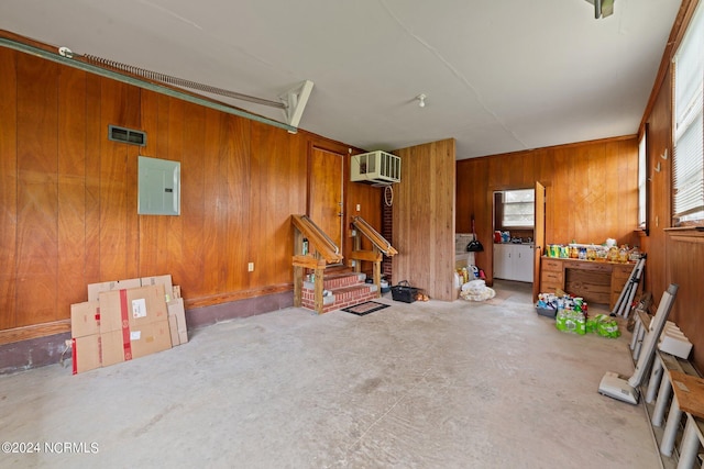 garage with electric panel and wooden walls