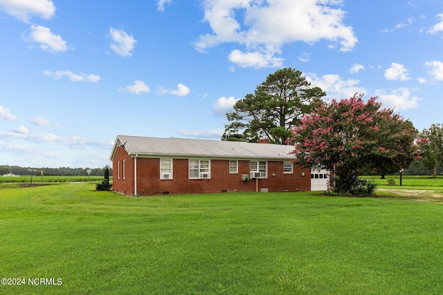 exterior space with a garage and a lawn