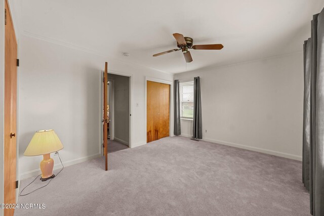 unfurnished bedroom with light colored carpet, a closet, and ceiling fan